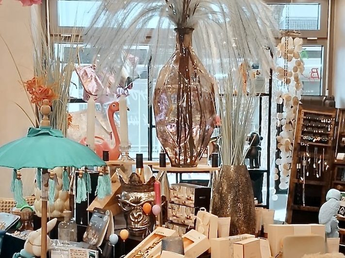 Dekorative Warenpräsentation im Conceptstore Innenansicht eines Conceptstores mit dekorativer Präsentation von Wohn- und Geschenkartikeln auf Tischen und Regalen