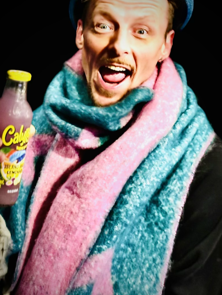 „Calypso® Getränk & Kundenmoment BSix®“ „Fröhlicher Kunde mit farbigem Schal und Calypso® Getränk im BSix® Conceptstore“