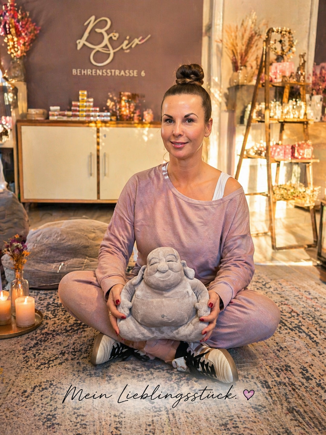 Buddha Figur in Anwendungssituation Frau sitzt in einem Raum mit Dekoration und hält eine Buddha Figur als Produktdarstellung